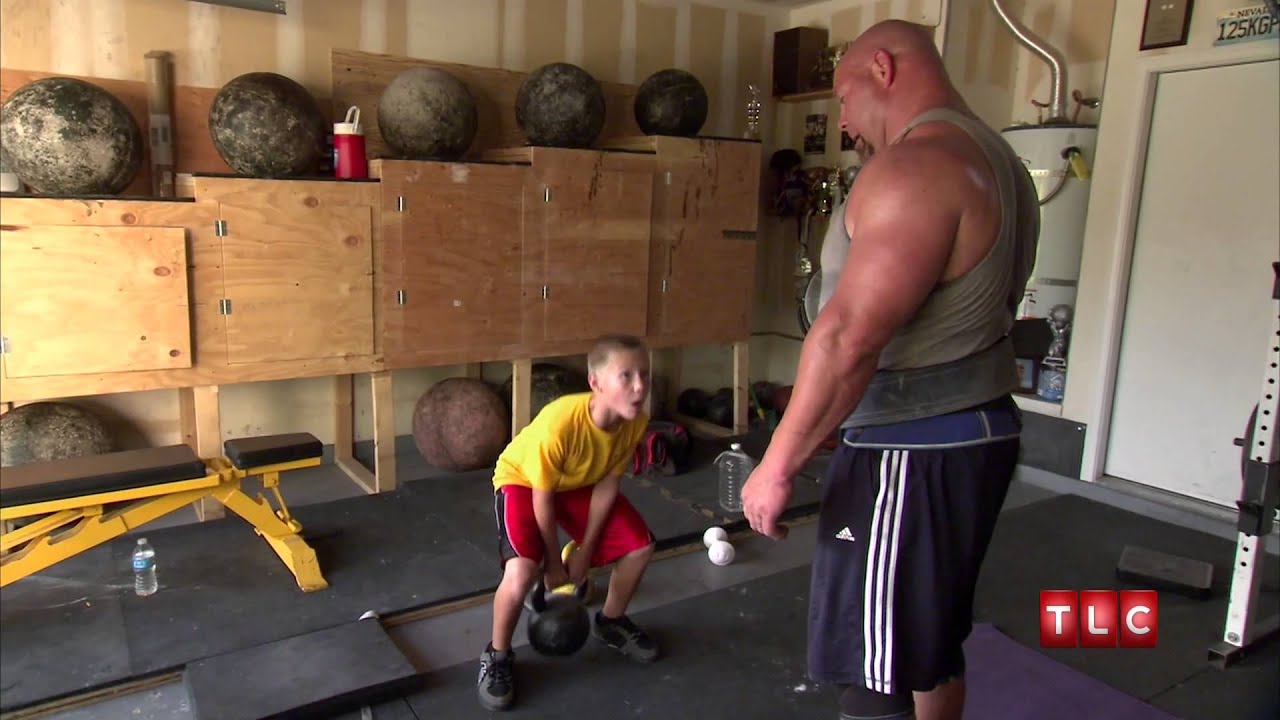 Nick Best coaching his son with a kettlebell in his home gym on TLC